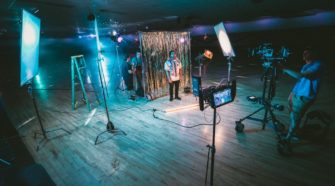 Videoproduktionstaette mit zwei Kameras, die auf einen Mann zeigen.