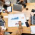Gruppen-Meeting mit Laptops und Charts