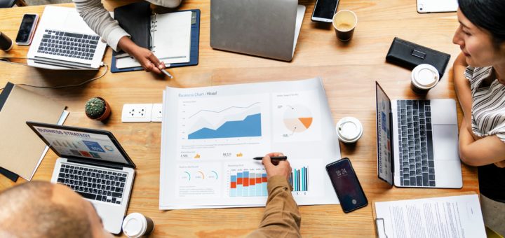 Gruppen-Meeting mit Laptops und Charts