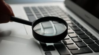 Lupe zeigt auf Laptop-Tastatur