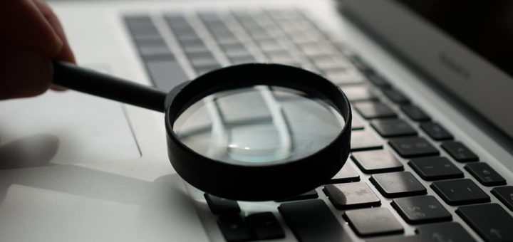 Lupe zeigt auf Laptop-Tastatur