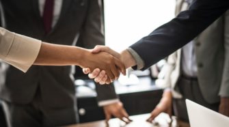 Zwei Menschen geben sich die Hand