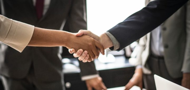 Zwei Menschen geben sich die Hand