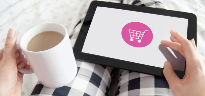Studie zu Reimagining Commerce: Frau in karierter Hose hält Kaffee-Tasse und Tablet auf dem Schoß für Onlineshopping & Einkaufsgewohnheiten
