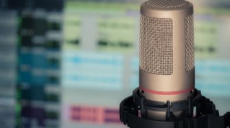 Podcast-Mikrofon vor Bildschirm mit Sound-Software
